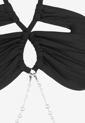 Czarny stanik z materiału z marszczonym wzorem i krzyżującymi się ramiączkami z tyłu. Udekorowany srebrnym łańcuszkiem i okrągłymi koralikami na środku.