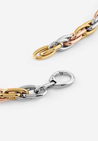 Schakelarmband met onderling verbonden ovale schakels in gouden, roségouden en zilveren tinten, met een zilveren kreeftsluiting.