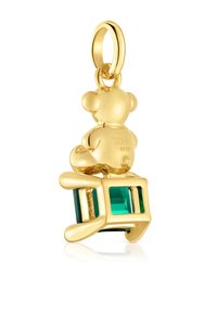 Złoty urok w kształcie niedźwiedzia siedzącego na zielonym klejnocie, charakteryzujący się gładką teksturą i wypolerowanym wykończeniem. Wygrawerowane logo oraz oznaczenie 925 widoczne na niedźwiedziu.