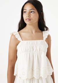 Cremefarbene, rüschierte Tanktop mit einem gerafften Oberteil und besticktem Lochmuster am Saum. Die Träger weisen geraffte elastische Details auf.