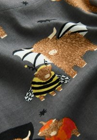 Een grijze stof met speelse dierenpatronen: een bruine beer met vleugels, een hommel en verschillende wezens met vleermuizen en kostuums.