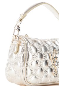 Borsa metallizzata oro con una texture trapuntata, dotata di un manico corto e di una cucitura intricata. Accenti in hardware dorato e dettaglio del logo visibili.