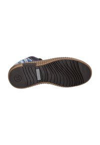 Suola nera della scarpa con scanalature testurizzate, dotata di un bordo marrone e un'etichetta grigia chiara. Il design include una leggera curvatura nella zona del tallone.