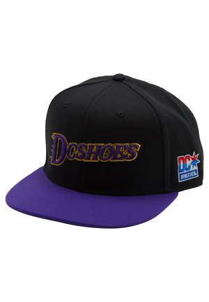 Gorra de béisbol negra con visera morada, que presenta el logotipo bordado de "Dcshoes" en dorado y un pequeño parche de logotipo multicolor en el lateral.