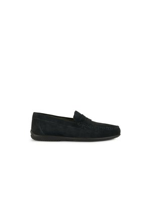 Mocassini neri in suede con suola piatta, caratterizzati da dettagli cuciti e una fascia decorativa sulla parte anteriore del piede. Texture liscia, design classico.