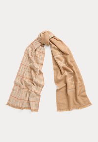 Bežs šalle ar rūtainu rakstu oranžā un krēmkrāsas tonī. Mīksta tekstūra ar fringētām malām un dekoratīvām burtnēm vienā pusē.