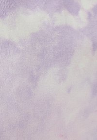 Tissu tie-dye en lavande pastel et blanc, présentant une texture douce et un motif semblable à des nuages, mettant en valeur des variations de couleur légères et subtiles.