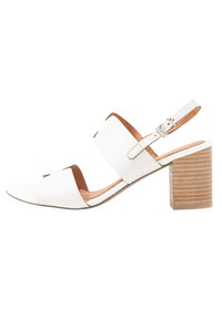 Sandali con tacco a blocco in pelle bianca, con punta aperta e cinturino alla caviglia regolabile; presentano dettagli in marrone e una texture liscia.