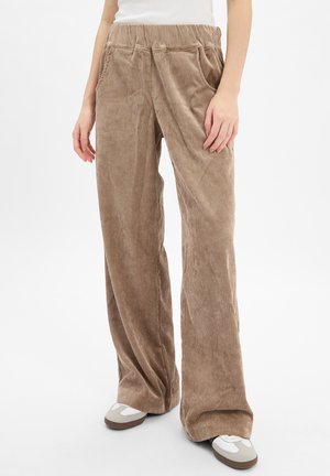 Weite Corduroy-Hosen in einem hellbraunen Farbton. Sie verfügen über ein strukturiertes, vertikales Rippmuster und einen elastischen Bund. Seitentaschen sind enthalten.