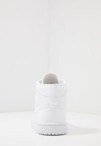 Höga vita sneakers med texturerat läder, vadderad krage och gummisula. Minimalistisk design utan synliga logotyper eller mönster.