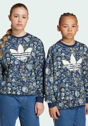 Floral-printed navy sweatshirts with white Adidas logo; features ribbed cuffs and hem, paired with blue denim jeans.