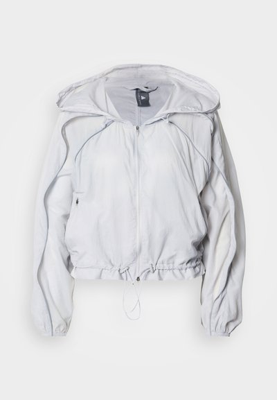 Ελαφρύ, λευκό μπουφάν ανεμοφράκτη με φερμουάρ μπροστά, ρυθμιζόμενο κορδόνι στο κάτω μέρος και κουκούλα. Διαθέτει μακριά μανίκια και πλαϊνές τσέπες. Με λεία υφή.