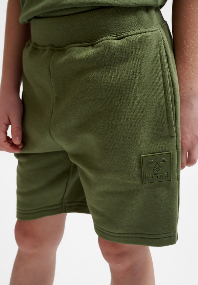 Gröna bomullsshorts med en mjuk textur, elastisk midja, sidofickor och ett upphöjt logotypmärke på vänster ben.