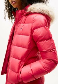 Czerwona kurtka puchowa z futrzanym kapturem, z pikowanym wzorem. Zamek błyskawiczny i elastyczne mankiety zapewniają dopasowanie. Logo marki na klatce piersiowej.