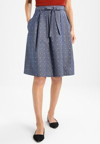 Denimkjol med en midje-längd design, ljusblå bas, spridda små hjärtan, sidofickor och en knytbar midjebälte.