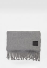 Siv kvačkan šal z resicami, gladka tekstura, pravokotni oblik, in črna tkaninska oznaka na eni strani.