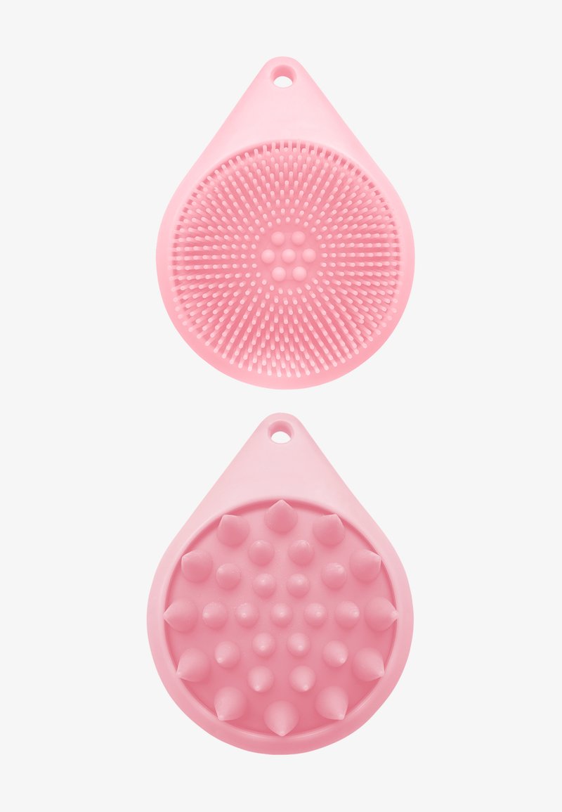 Różowy masażer skóry głowy z silikonu. Posiada dwie teksturowane strony: jedna z krótkimi, okrągłymi włoskami, a druga z miękkimi, spiczastymi wypustkami.