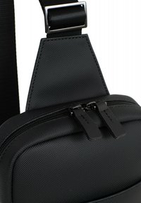 Borsa a tracolla nera con superficie in nylon testurizzato, chiusura con doppia zip e tiranti piatti, e tracolla regolabile con fibbia in metallo.