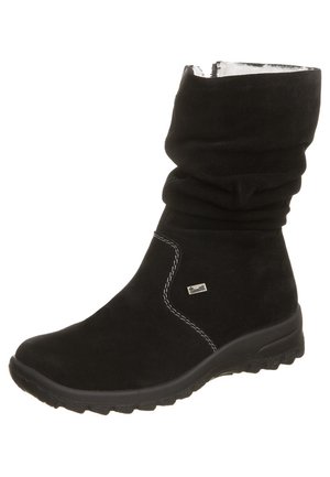 Czarny zamszowy botek do połowy łydki z luźnym cholewką, bocznym zamkiem błyskawicznym, białym przeszyciem, gumową podeszwą oraz małą prostokątną metką logo z boku.