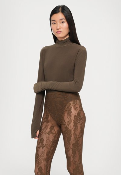 Brun mock-neck langermet topp kombinert med gjennomsiktige brune blondelleggings med blomsterdesign. Glatt tekstur, tettsittende design og full dekning.