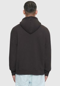Schwarzer Pullover-Hoodie mit Kordelzugkapuze, abfallenden Schultern und gerippten Bündchen. Weiches Baumwollmischmaterial mit lockerer Passform.