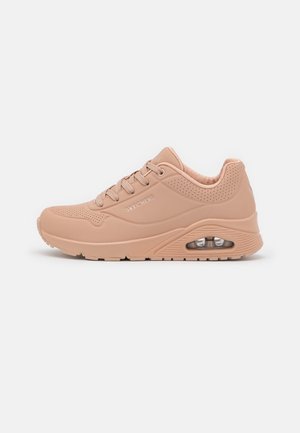 Beżowy sneaker Skechers z amortyzowaną podeszwą, detalem z kieszenią powietrzną, perforowaną cholewką, sznurowaniem z przodu i wyściełanym kołnierzem dla komfortu.