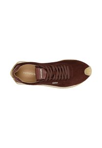 Baskets en daim marron avec un bout arrondi, lacets plats et une semelle en caoutchouc texturé. Présente un petit logo sur le côté.