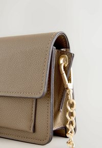 Sac à main en cuir vert olive texturé avec fermeture à rabat. Éléments métalliques dorés et bandoulière chaîne. Forme rectangulaire compacte.