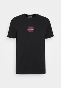 T-shirt en coton noir avec un texte graphique "CURIOSITY DISCOVERY" en blanc et violet sur le devant. Manches courtes et col rond.