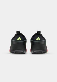 Zapatillas deportivas negras y verde neón con parte superior texturizada, suela acolchada y tirador en la parte trasera. Presenta tres acentos a rayas en el talón.