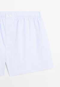 Shorts in cotone azzurro chiaro con vita elasticizzata, dotati di chiusura a bottone e una tasca cucita su un lato.