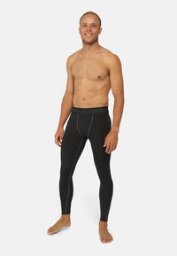 Mustat puristavat leggingsit, joissa on vaaleansinisiä ompeleita ja mukava elastinen vyötärö, jossa on merkintä "Danish Endurance". Materiaali näyttää sileältä ja joustavalta.