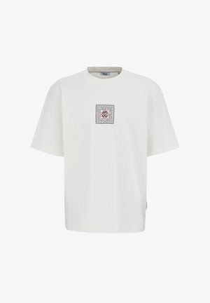 Valge puuvillane lühikeste varrukatega t-särk. Rindkere piirkonnas ruudukujuline tikand punases ja mustas värvitoonis. Sirge lõige ja lõdvestunud istuvus.