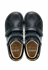 Scarpe in pelle nera con due cinturini in velcro, punta tondeggiante e interno color sabbia con logo del brand impresso. Finitura liscia e resistente.