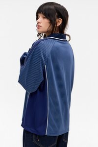 Camisa azul-marinho de manga curta com riscas verticais, detalhes brancos e colarinho clássico, feita de um tecido suave e brilhante.