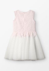 Lichtroze kanten lijfje jurk met een witte tule rok, mouwloos ontwerp en een gegolfde rand bij de taille. Ritssluiting aan de achterkant.