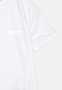 Tricou sportiv alb, fabricat dintr-un material respirabil, cu mâneci raglan și un logo subtil pe piept. Textură fină și design minimalist.