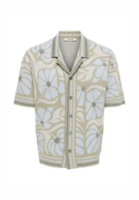 Chemise boutonnée à manches courtes avec col, présentant un motif floral bleu clair et une bordure zigzag en tons beige, gris et blanc.