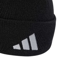 Black knitted beanie with a folded cuff, featuring three white diagonal stripes embroidered on the side. Textured fabric.