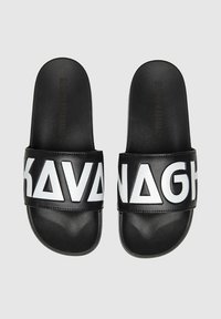 Infradito neri con grande scritta bianca "KAVANAGH". Realizzati in materiale sintetico, presentano una texture liscia e un design a suola piatta.