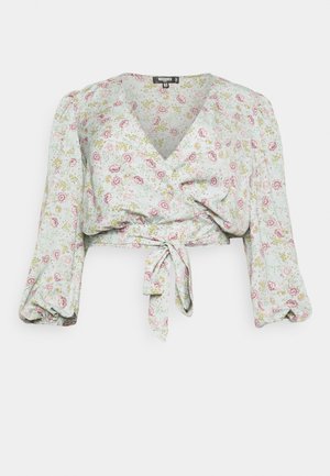 Blusa envolvente floral em verde claro, com padrões de rosas cor-de-rosa. Mangas longas e volumosas com detalhe de laço na frente. Tecido macio com um ajuste descontraído.