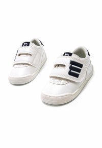 Zapatillas blancas de cuero con dos correas de Velcro, un logotipo de acento en navy y una suela de goma texturizada para agarre y durabilidad.