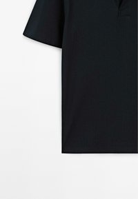Polo nero a maniche corte, realizzato in un tessuto testurizzato e dotato di colletto classico. Il design è semplice e senza cuciture all'orlo.
