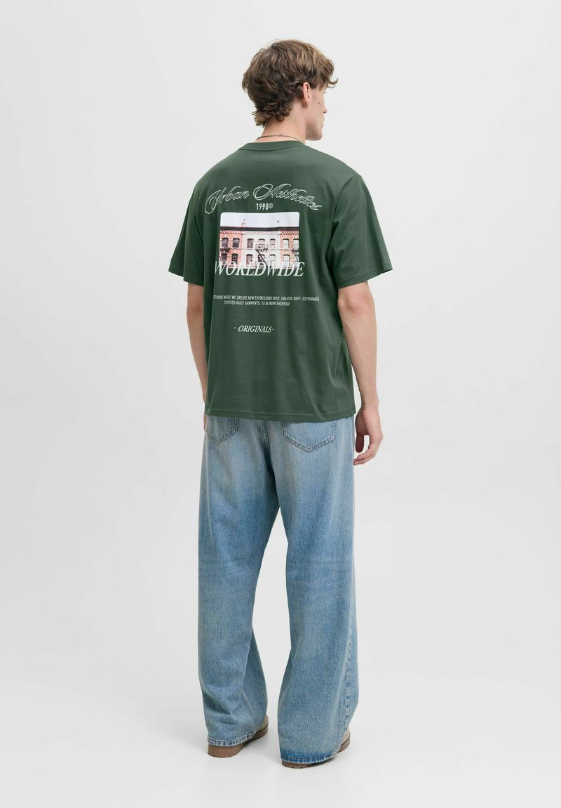 Roheline puuvillane t-särk, millel on graafikaprindiga ja tekstiga seljaosas. Ühendatud lodevate helesiniste teksadega. Lihtne ümmargune kaelus.