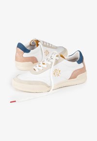 Zapatillas blancas con detalles en beige, rosa y azul. Suela de goma texturizada y cordones, con un diseño de logo en naranja en el lateral.