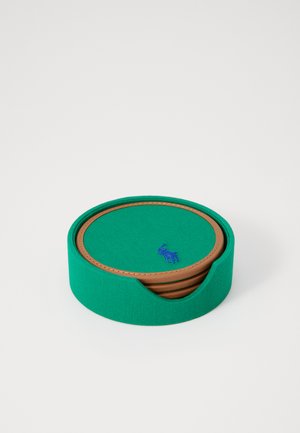 Zelena herringbone tkanina podložke z okroglimi robovi in rjavimi usnjenimi poudarki, z majhnim modrim emblemom. Zložljiva zasnova.