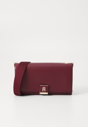 Dunkelrotes, strukturiertes Leder-Umhängetäschchen mit breitem Träger und goldfarbenem rechteckigem Verschluss mit ineinandergreifenden Initialen.