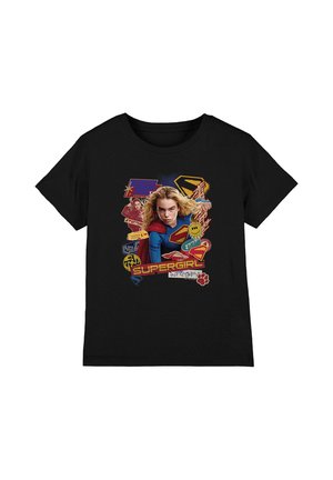 Black t-shirt featuring Supergirl in costume flying forward, surrounded by logos, comic-style graphics, and the word "Supergirl" in bold letters.
