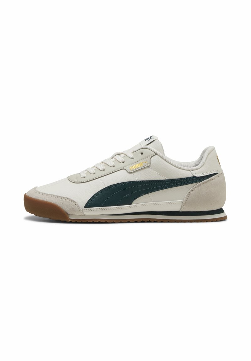 Hvide lædersneakers med mørkegrøn Puma-stribe, gummisål, snørebåndsdesign og et suede-indsats på hælen. Guld logo-detalje.