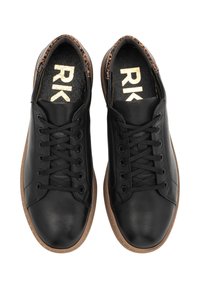 Black leather sneakers with lace closure, round toe, textured insole, and brown rubber outsole. Gold branding visible inside.